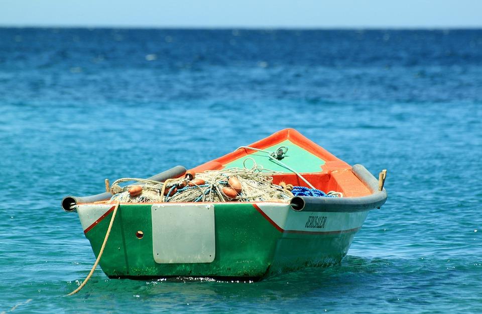 Łódka z sieciami rybackimi zacumowana przy plaży.