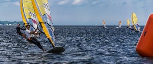 grupa mężczyzn trenuje windsurfing na morzu