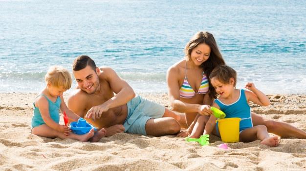 rodzina z dziećmi bawi się na plaży nad morzem